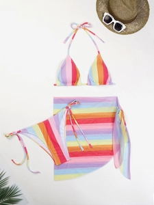 Flat lay of colorful striped three-piece bikini set with a matching mesh sarong wrap