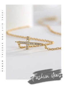Macro shot of gold cross necklace with pavé-set clear cubic zirconia crystals