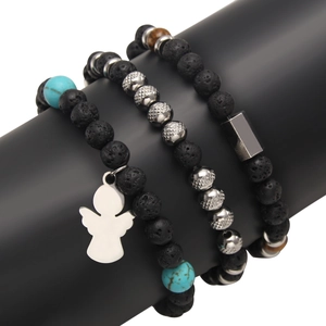 Natural lava stone beaded bracelets set with angel pendant on black jewelry display stand