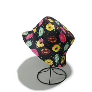 Détail d'un bob noir avec des imprimés de donuts style pop art aux couleurs vives