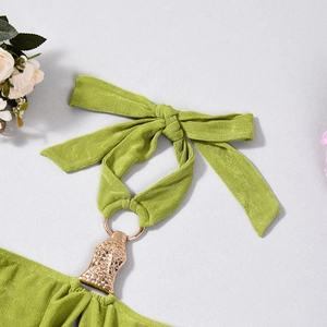 Gros plan sur une robe dos nu verte avec maille texturée et boucle métallique dorée