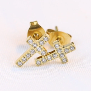 Macro shot of gold cross stud earrings featuring micro-pave set sparkling cubic zirconia