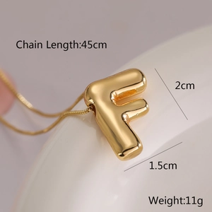 Detailed view of golden letter F balloon pendant necklace with dimension measurements