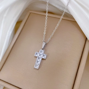 Close-up of silver titanium steel cross pendant necklace with square cubic zirconia