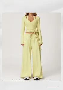Detail of light yellow yoga set showing the cross-over tie waist and wide-leg pant texture