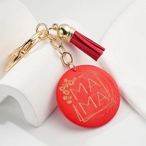 Close-up of red wooden MAMA pendant with floral carving and red suede tassel keychain