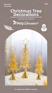 Close-up of golden wire Christmas tree set with star toppers and bells for desk decor