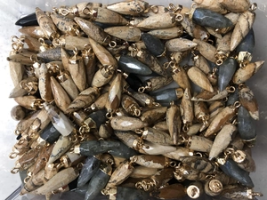 Detailed pile of natural stone cone pendants featuring agate and obsidian textures with gold loops