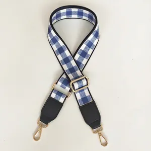 Detail of blue checkered strap with black leather trim and adjustable gold metal buckle