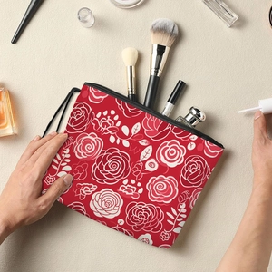 Floral makeup bag with red base and white rose pattern featuring a zipper and handle strap