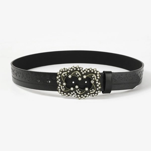 Close-up of black punk belt with ornate rhinestone buckle and embossed star patterns
