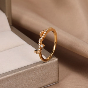 Detailed view of a gold rose vine ring with sparkling zircon crystals on silk fabric