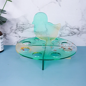 Detail view of a green translucent chick-shaped resin holder with gold foil flakes