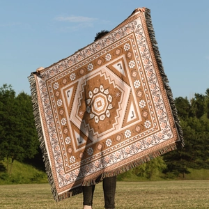 Close-up of bohemian geometric mandala knit blanket with colorful fringe details