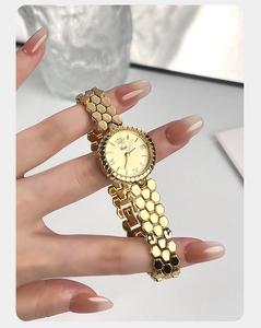 Detailed view of the golden honeycomb bracelet watch with champagne dial and Roman numerals