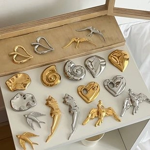 Flat lay of vintage gold and silver resin bangles with geometric and nature shapes