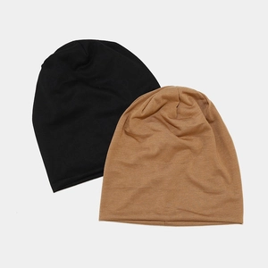 Détail de bonnets tombants noir et marron clair en maille douce double épaisseur