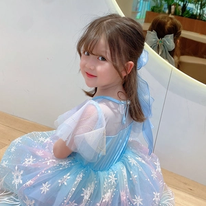 Detail of blue snowflake princess dress with mesh layers and matching bow hairclip accessory