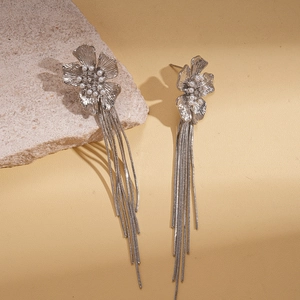 Silver flower tassel earrings with pearls and zircon crystals on natural stone background