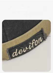 Detailed close-up of embroidered letters and distressed edges on a vintage docker cap