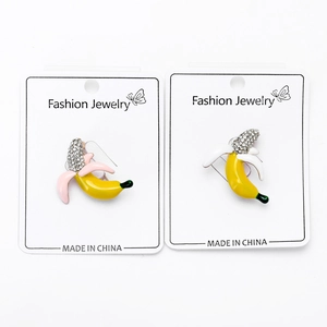 Detail of banana brooches with sparkling rhinestones and pink enamel finish on card