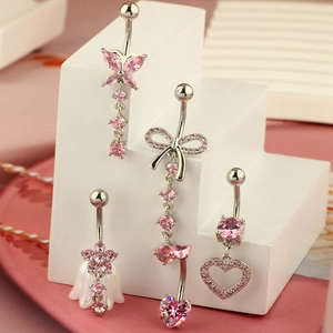 Detailed macro view of four pink zircon belly rings with butterfly and floral charms