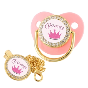 Detail of pink crown princess baby pacifier with gold chain clip and rhinestone accents