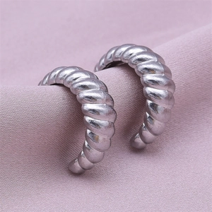 Detail of silver 304 stainless steel twisted hoop earrings on purple fabric texture