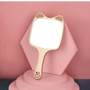 Cute cat-eared wooden hand mirror with paw print cutout on a pink studio stand