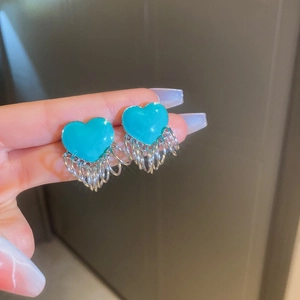 Detailed shot of teal heart earrings with cascading silver chain tassels and smooth finish