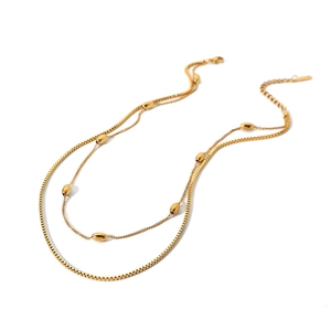 Elegant gold double layer necklace with oval beads and box chain on white background