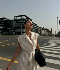 Detail of linen texture on sleeveless cream maxi dress with lapel and waist tie