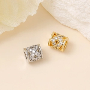 Macro view of hollow wing-shaped charms with pave cubic zirconia in gold and silver