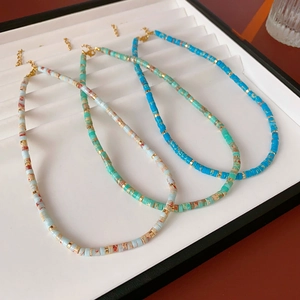 Detailed flat lay of three round Shoushan stone beaded necklaces with gold accents and clasps