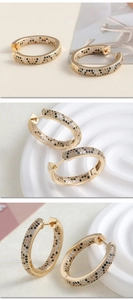 Detail of leopard print hoop earrings with black and champagne pavé zircons in gold finish