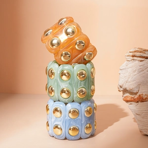 Detail of acrylic marble texture bracelets with golden studs in multiple colors