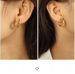 Macro shot of 3D dragon head hoop earrings in retro gold finish on a model