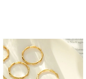 Detailed close-up of golden bamboo texture rings on a vintage aesthetic background