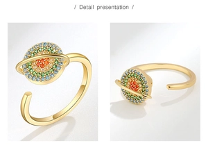 Détail macro d'une bague planète avec strass colorés sur anneau en argent doré
