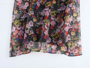 Detail of floral organza dress showing black chiffon fabric with rose pattern and soft drape