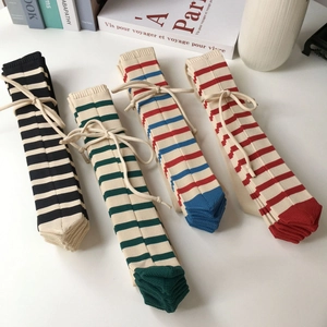 Set of four colorful striped knit shoulder bags with ribbon ties on white background