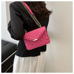 Chic rose red quilted PU leather crossbody bag with gold chain strap on female model
