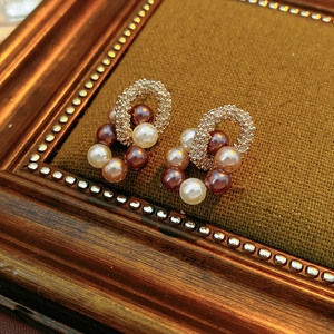 Détail de boucles d'oreilles vintage avec perles et métal doré sur fond de velours
