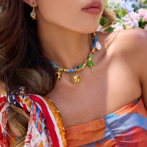 Detail of bohemian fabric rope necklace with colorful charms and starfish earrings