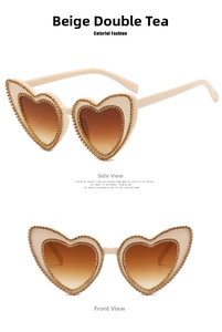Detail of cream heart-shaped sunglasses with rhinestone borders and brown gradient lenses