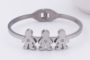 Detail of silver open bangle with three character shapes inlaid with zircon stones