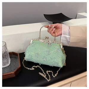 Detail of mint green clutch bag with 3D floral lace embroidery and gold kiss lock
