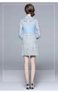 Detail view of the elegant lace back design and tweed texture on a light blue dress