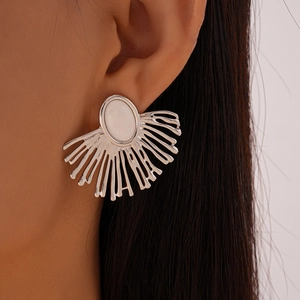 Detailed close-up of a silver fan-shaped earring with white stone on a model's ear