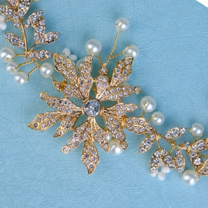 Detail of handmade gold flower headband with sparkling rhinestones and white pearls